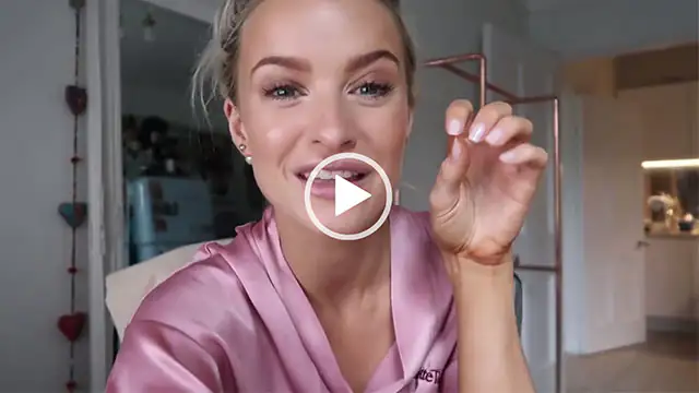 Victoria Magrath taps her fingernails together. She wears her blonde highlight hair tied back. Victoria sits on an office chair in a light pink Charlotte Tilbury dressing gown.