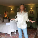 Josie Irons stands with her hands spread out. She wears a light shirt with a pair of blue jeans. Josie is seen in one of the bedrooms of her home in the Cotswolds.